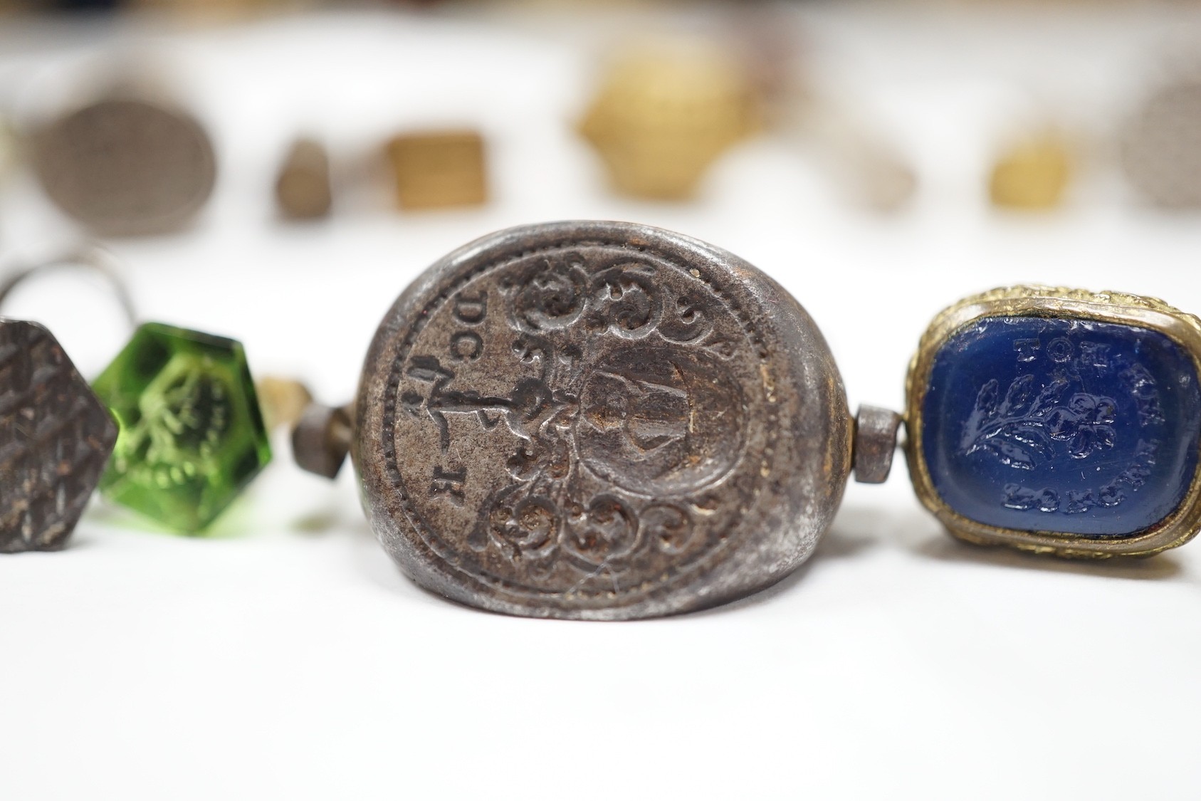 A group of twenty-five steel, gilt metal or nickel fob or desk seals, mostly 19th-century, including a steel swivel seal, a seal with boxwood finial modelled as a hand holding a ball and a nickel multi seal